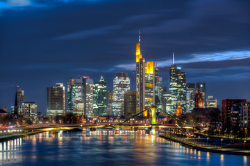 Die Skyline der Frankfurter Innenstadt mit Hochhauskulisse am Abend vom Fluß Main aus gesehen