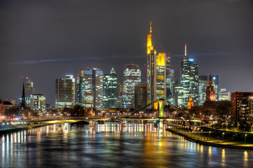 Fototapeta na wymiar Die Skyline der Frankfurter Innenstadt mit Hochhauskulisse am Abend vom Fluß Main aus gesehen