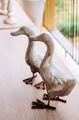 Ornamental duck family stone sculpture on wood table