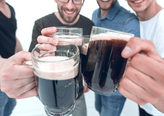 close up.mugs of beer in the hands of a group of men