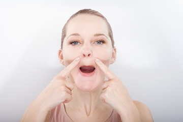 facial gymnastics. the girl does massage and rejuvenating exercises for the face