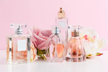 Fotobehang Bottle of perfume with flowers on color background © NewFabrika