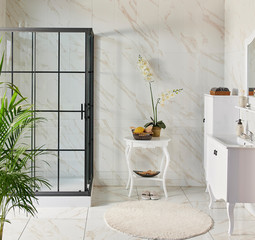 Modern black grid shower style with sink and cabinet. white table and vase of flower..