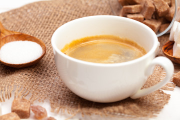 Coffee mug with slices of sugar on wooden table