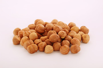 A pile of hazelnuts at white background