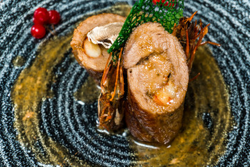 pork stuffed with shrimp in a black plate on a wooden table