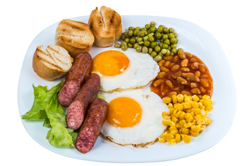 breakfast fried egg peas, corn grains, beans and fried sausages on a white plate isolated