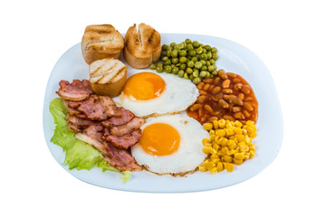 breakfast fried egg peas, corn grains, beans and fried bacon on a white plate isolated