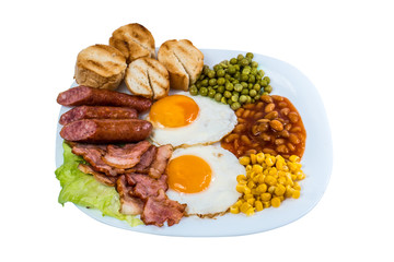 breakfast fried egg peas, corn grains, beans fried sausages and fried bacon on a white plate isolated