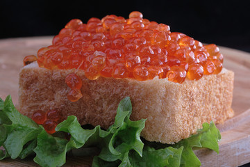 Red caviar on a wooden table
