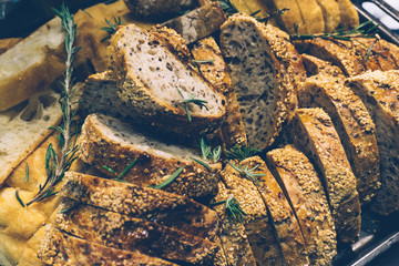 Homemade grain bread with herbs, rosemary and sesame. Sliced to preheat. Home cooking concept.