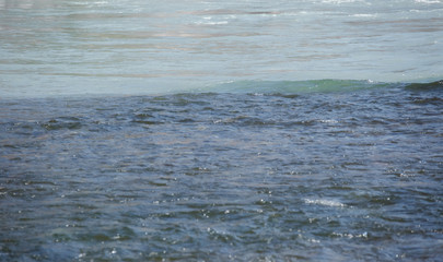 Mountain, transparent river, flowing among smooth stones. River confluence, two different colors