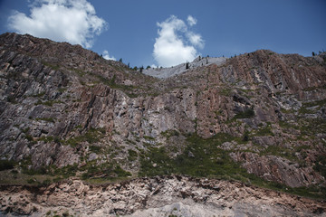 Close-up mountains. Stone wall with moss and vegetation.