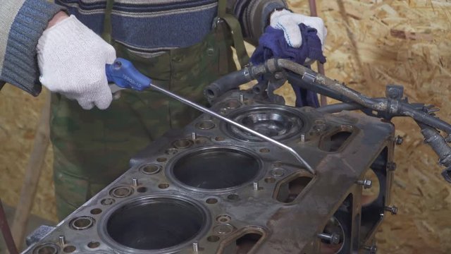 A mechanic cleans a compressor large car engine