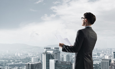 Concept of business success and control with confident boss against cityscape background