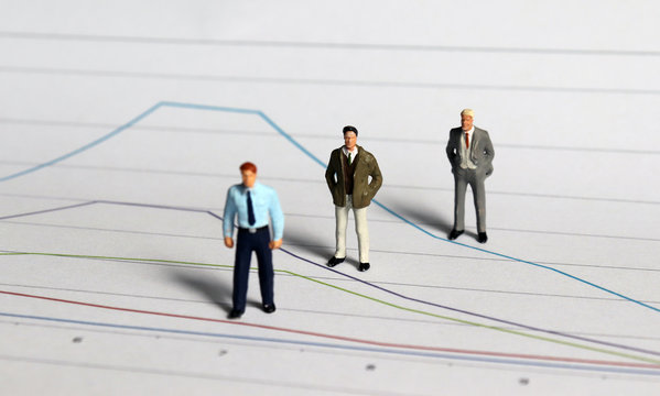 Miniature people standing on linear graphs.