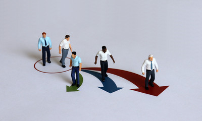 Miniature men positioned in different directions. Business concepts and miniature people.