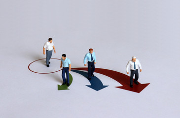 Miniature people positioned in different directions.