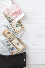 Close-Up of dollars and euros on wooden background. Wallet with dollars. Hidden revenue. illegal money