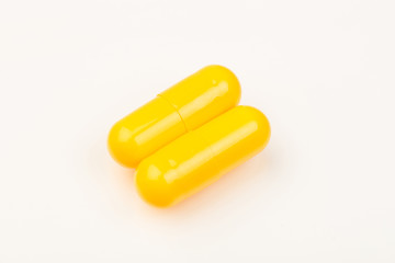 yellow capsules close up on white background