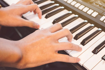 Boy's hand playing piano, Hands playing the synthesizer keyboard, Playing Piano, Hands of young...