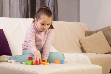 autistic girl concentrating playing with blocks. the girl does not respond to the world around us. immersed in thought
