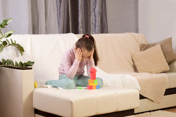 autistic girl concentrating playing with blocks. the girl does not respond to the world around us. immersed in thought