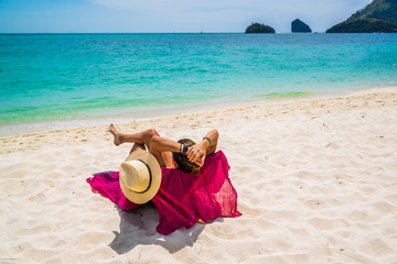 Fototapeta na wymiar Woman enjoying her holidays on a transat at the tropical beach
