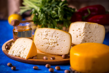 Cheese wheel on a wooden board. Blurred background.