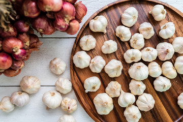 garlic and red onion on wooden plate