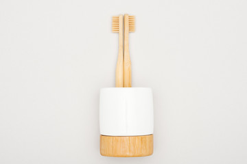 bamboo toothbrushes in stand on grey background