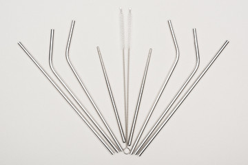 flat lay with stainless steel straws and cleaning brushes on grey