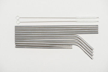 flat lay with stainless steel straws and cleaning brushes isolated on grey