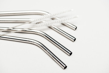 close up view of of stainless steel straws and cleaning brushes isolated on grey