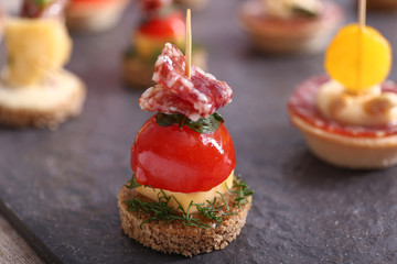 Tasty canape on slate plate, closeup