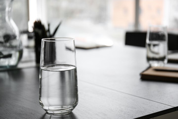 Glass of water on table prepared for business meeting in conference hall