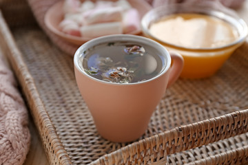 Cup of hot tea on wicker tray