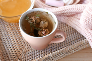 Cup of hot tea on wicker tray
