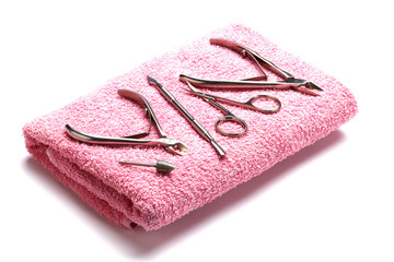 A set of tools for manicure on a pink towel. Insulation. Isolated