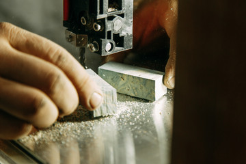 Cutting parts made of wood on the bandsaw. Wood processing workshop.