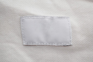 White blank clothing label on cotton shirt background