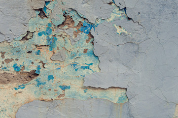 Texture of cracked grey, blue and yellow wall background.