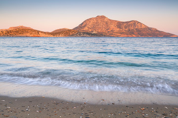 Beach in the town of Fourni and view of Thymaina island early in the morning, Greece. 