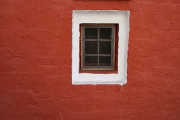 Old window on the background of a red brick wall. Moscow Russia