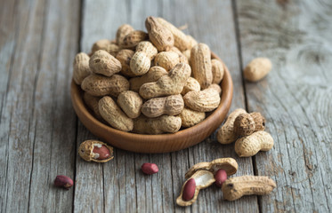 Close up view of shelled peanuts in wooden background.