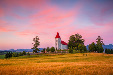 Rural landscape with wheat field and a church in Turiec region, central Slovakia.