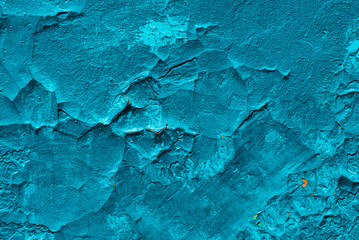 Imperfect concrete surface. Cracked blue paint close-up. Damage texture in macro. Grungy plaster. Old stucco textured background. Rough faded uneven obsolete wall. Peeling of old paint. Flaking of dye