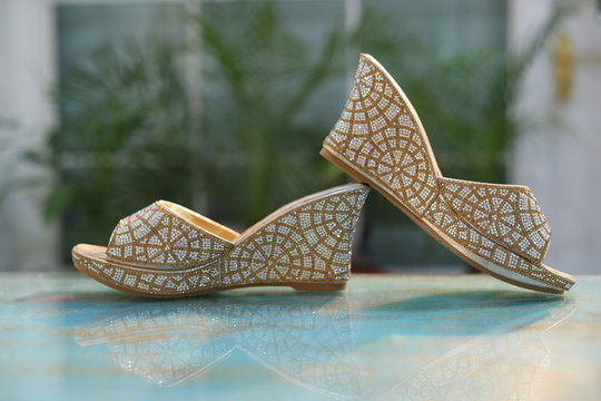 A pair of golden glittery nice bride sandals high heel fashionable peep toe design