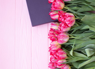 Pink tulip flowers bouquet and gift box over wooden background. Women day or birthday celebration concept