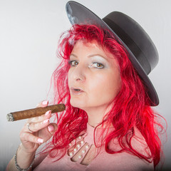 Hübsche Frau mit Hut, Zigarre und roten Haaren